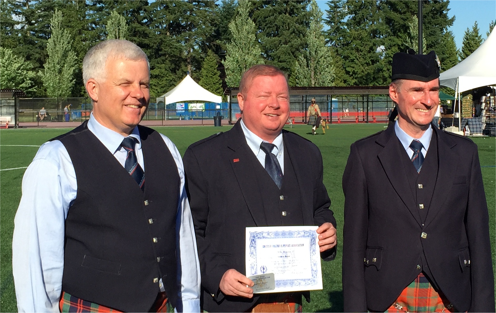 Andrew Bonar, centre, receiving an Honourary Life Membership to the BCPA from former SFU Pipe-Major Terry (left) and BCPA President Rob MacNeil, in June 2015.