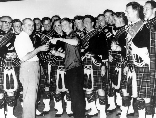 A photo taken in 1966 when Gavin Stoddart was a guest piper with the Edinburgh City Police Pipe Band on a trip to Moscow, which coincided with Stoddart's eighteenth birthday. The band was there for a British trade fair and the band threw a surprise birthday party for him. L-R: Ronnie Ackroyd, Chris Anderson, Chief Inspector and Band Secretary Willie Orr, George Lumsden, Jimmy Orr, Tam Richie (looking up), L-D Bob Montgomery, Gavin Stoddart, Bob Gibson (his left eye), Neil Sumner, P-M Iain McLeod, Harry McNulty (his left eye), David Laird, Murdo Murray, Alex Shand, D-M Jimmy Hermiston, Lawrie Gillespie.
