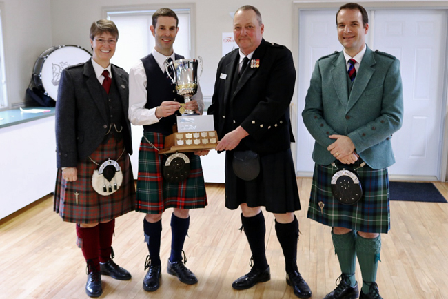 James MacHattie (2nd left) accepts the 2016 Atlantic Canada Piobaireachd Challenge trophy from Atlantic Canada Pipe Band Association's Rick Crawford, with College of Piping & Celtic Performing Arts Director Karen Hatcher (far left) and adjudicator Alan Bevan.