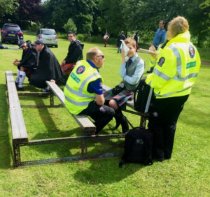 Brodie Watson-Massey being tended to by paramedics at Thornton Games, while fellow competitors sit by.