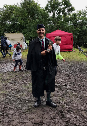 Jori Chisholm with the Glenisla Challenge Cup at a muddy ground.