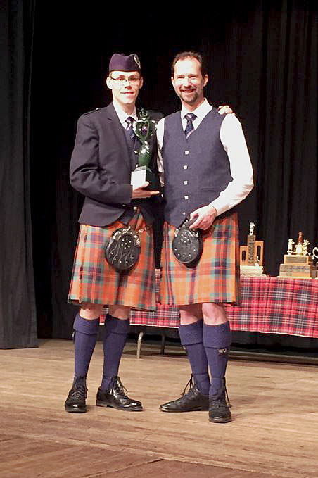 Zephan Knichel (left) receives the Darleen Mijaria Memorial Trophy from Derek Milloy for winning the CPA Piobaireachd event.
