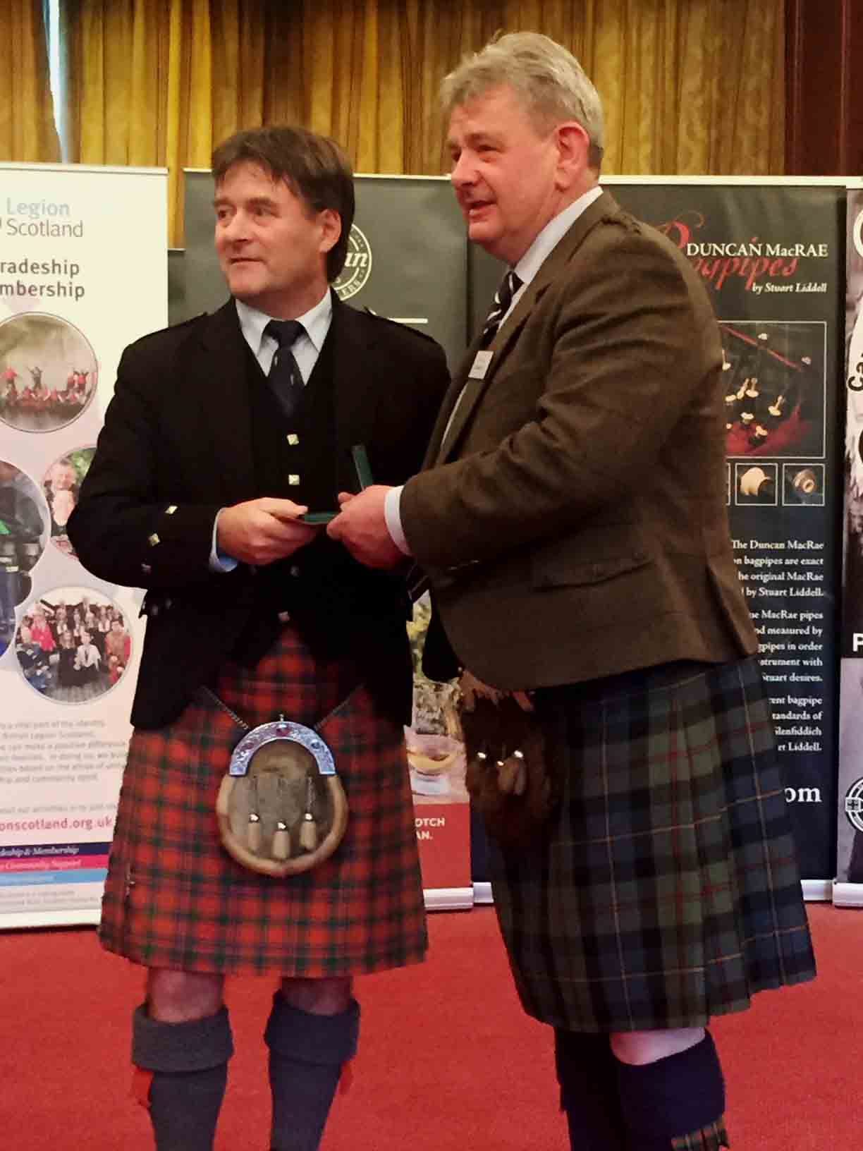 Angus D. MacColl receives a prize from Colin R. MacLellan at the 2018 Capt. John A. MacLellan MBE Championship.