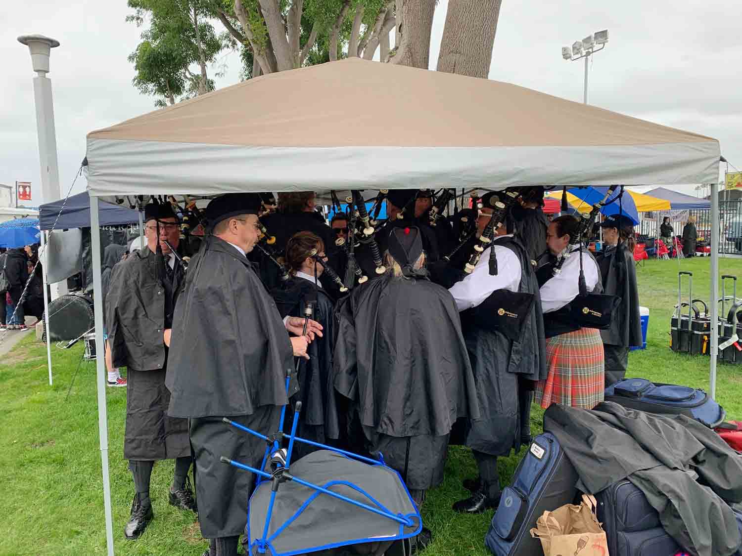 A band takes cover from the rain while tuning for the second day of the Costa Mesa games.