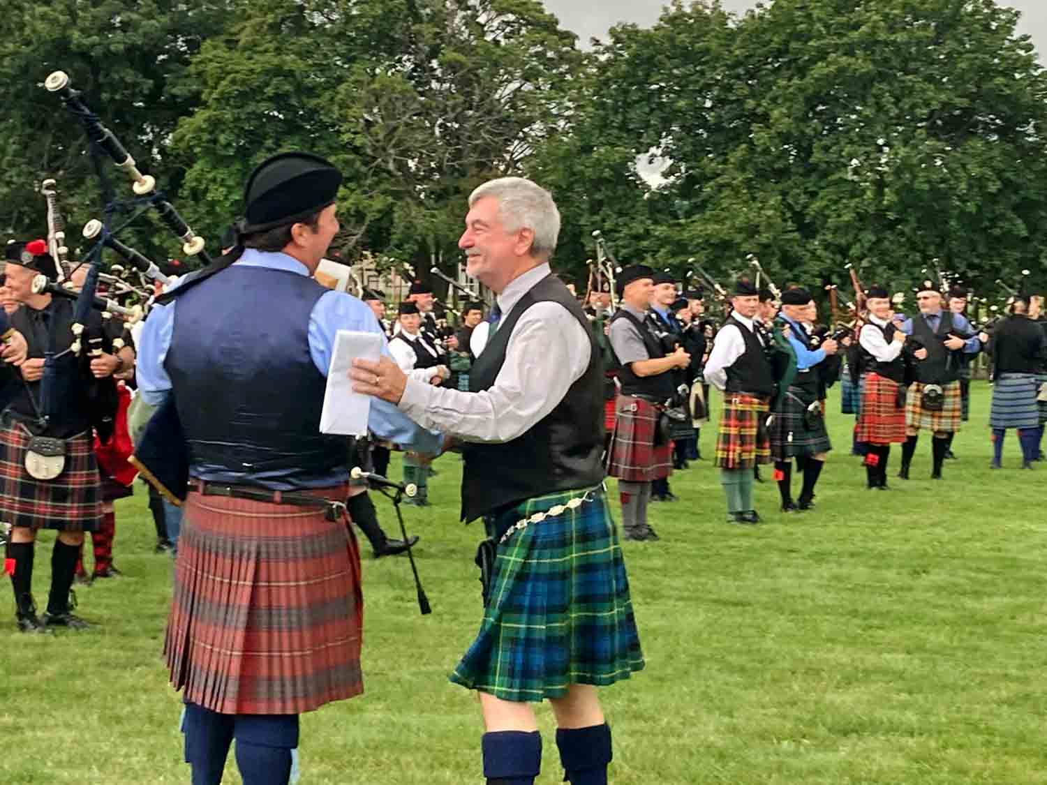 MWPBA President Jim Sim congratulates Pipe-Major Patrick Lynch of the City of Chicago Pipe Band at the 2021 Wisconsin Games.
