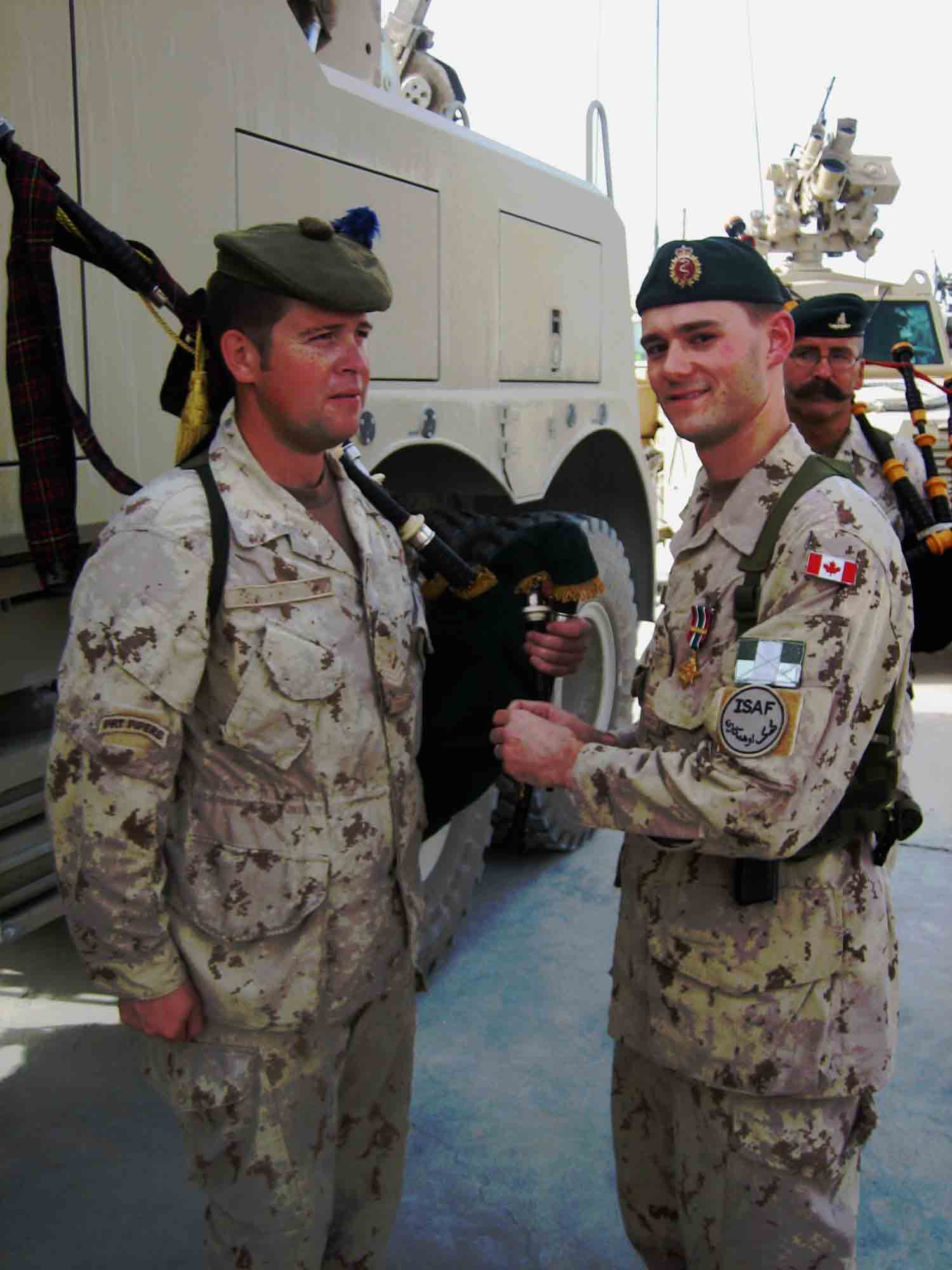 Captain Tylere Couture presents the General Campaign Star to Sergeant John Dawson while MWO Norris looks on.