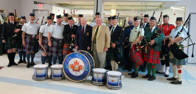 The impromptu pipe band honouring Bill Gilmour on November 28th in Ottawa. Pipe-Major Gilmour is at the centre of the picture with Dr. George Fraser to his right and Pipe-Major (Chief Warrant Officer Retired) Hugh Macpherson is to his left. Colonel Bruce Bolton is at far extreme right of the picture in a day jacket and Royal Stuart kilt, behind him is Gilbert Young in the wearing red tunic, and Bethany Bisaillion is furthest left.