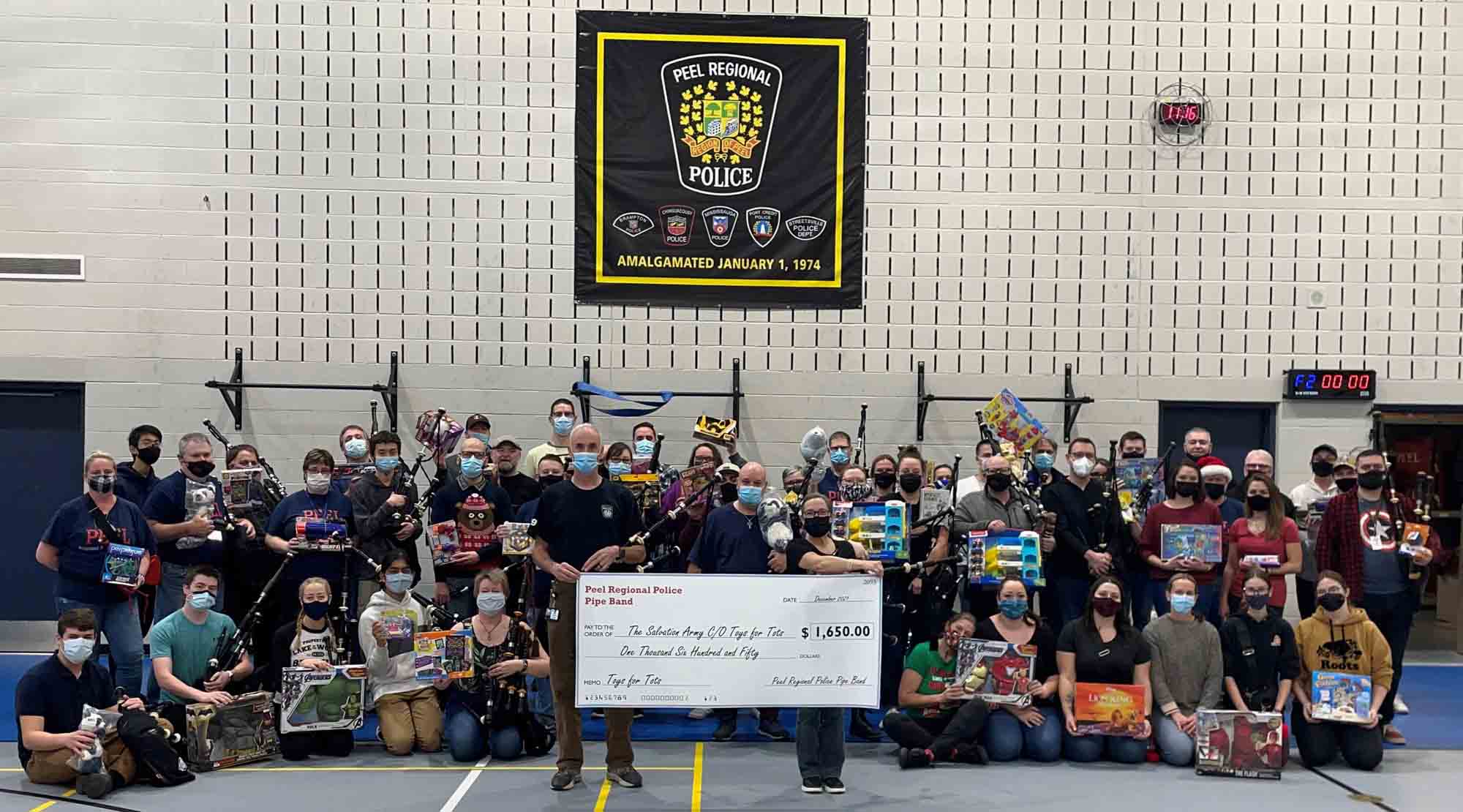 Members of the Peel Regional Police pipe band organization gather to celebrate their donations to the 2021 Toys for Tots police force campaign.