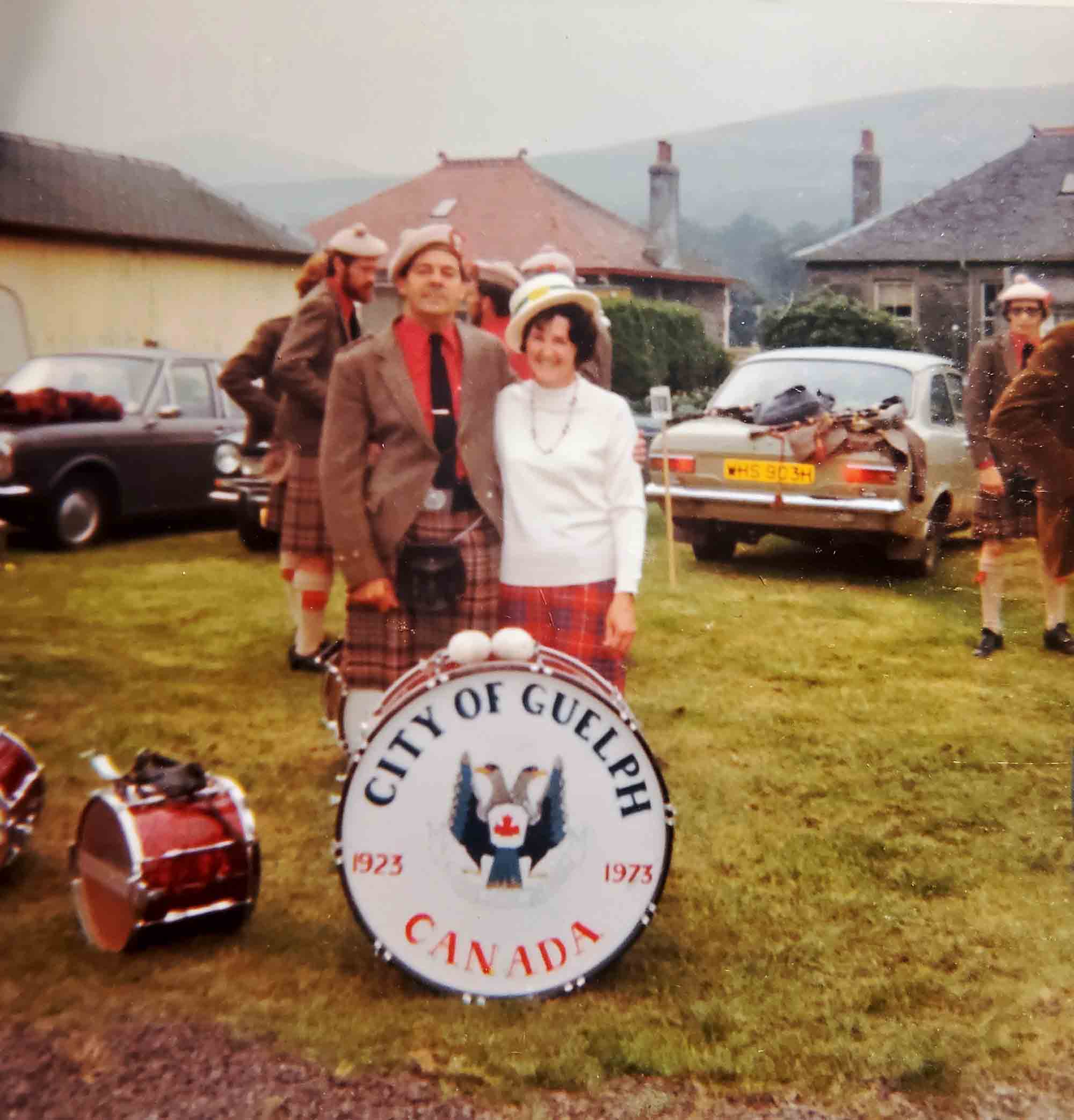 Taken at the Cowal Highland Gathering in 1974, the band wore distinctive orange shirts, tweed jackets, balmorals and plain brogues for several years, a nod perhaps to Neigh's solo piping work in Scotland. Guelph was one of the first non-UK/Ireland bands to compete in Great Britain. This is bass drummer Jack Harris with a Cowal Games representative. Ed Neigh is over his should, left.