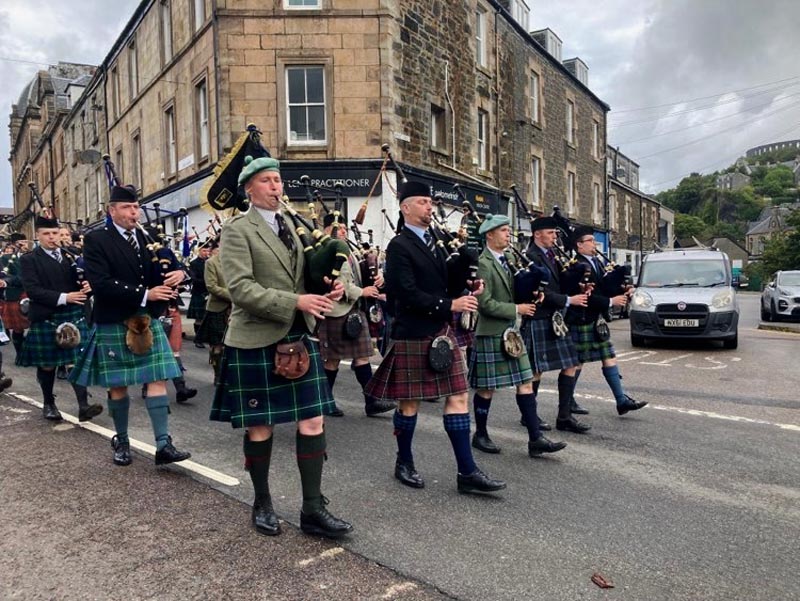 The 2022 Thursday pipers march to the Argyllshire Gathering park, with 2022 Oban Gold Medallist in the pipe-major's poisition.