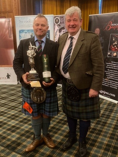 Stuart Liddell (left), winner of the Premier Grade MSR at the 2022 Captain John MacLellan Memorial solo competition, with judge Colin MacLellan.