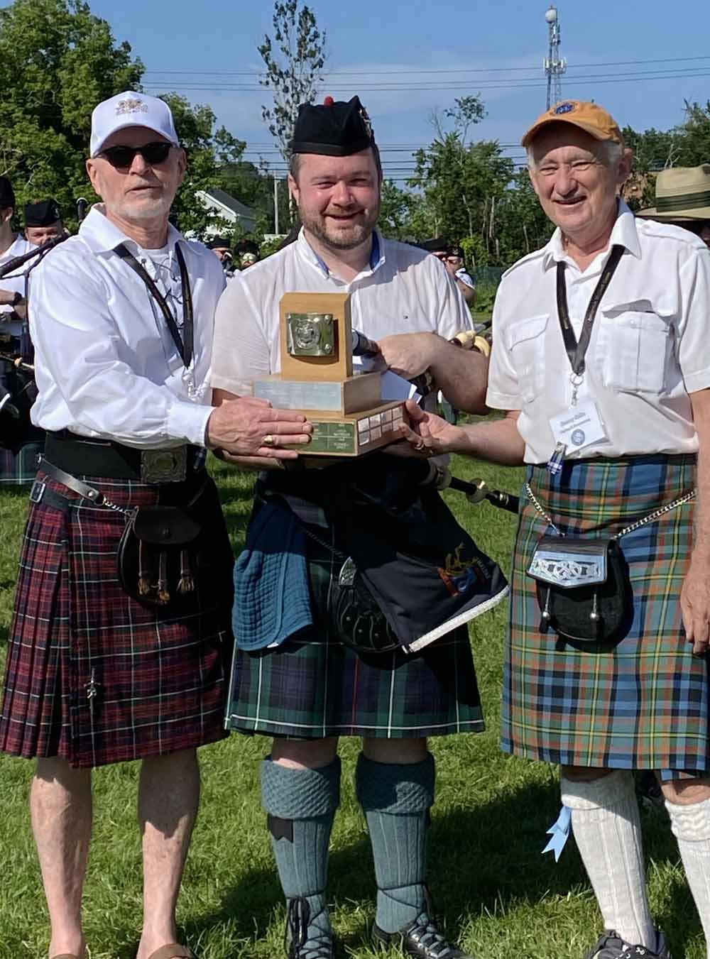 Alex Gandy receives some swank hardware for his Professional solo piping prowess at Antigonish.