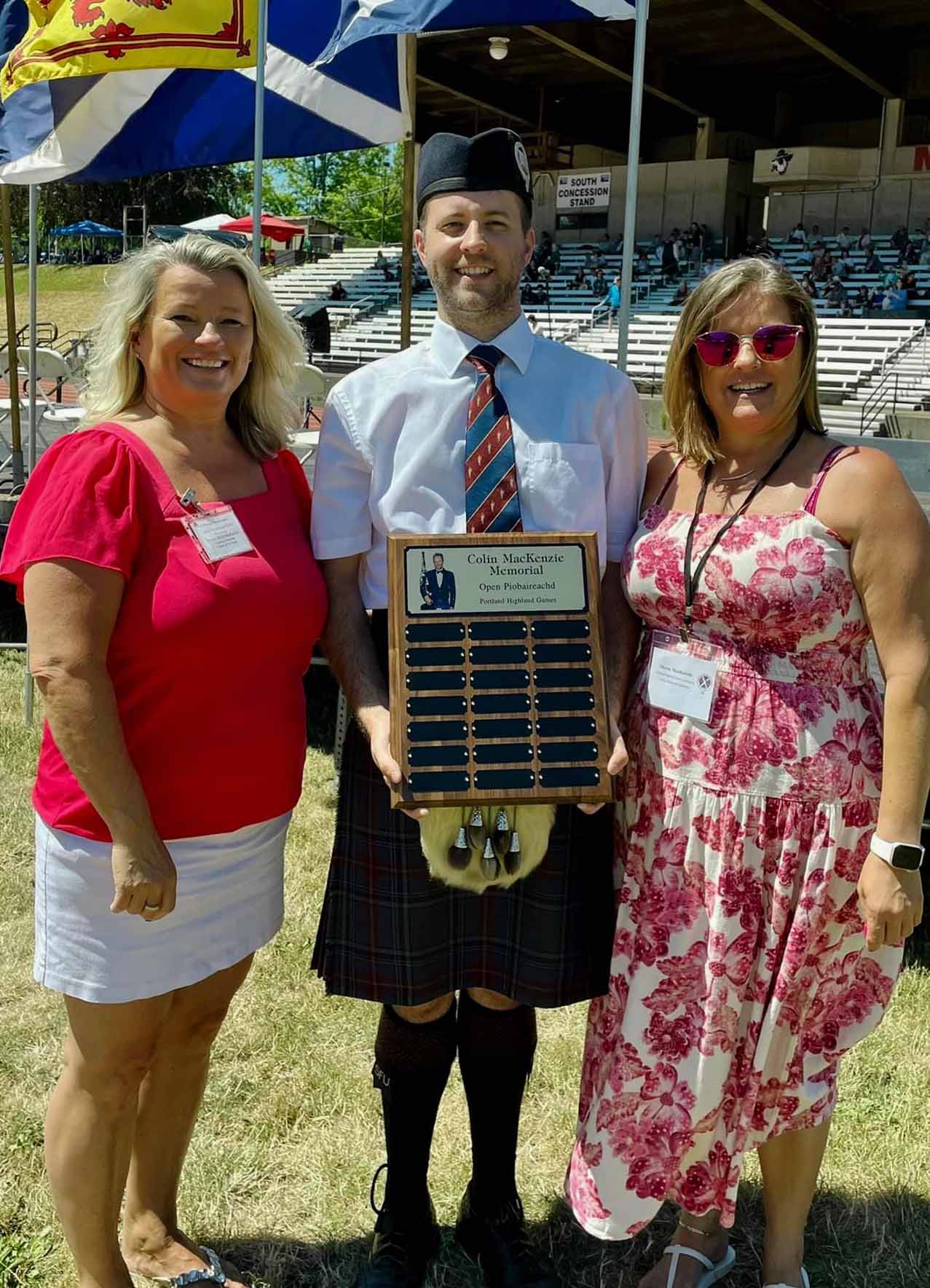 Alastair Lee with the inaugural Colin MacKenzie Memorial Award for Open Piobaireachd, presented by MacKenzie's daughters, Shona and Holly, at the 2023 Portland Highland Games.