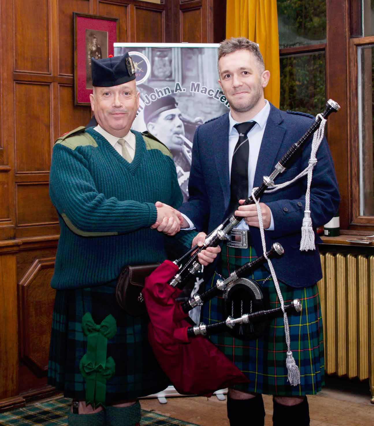 Andrew Smith receiving a prize set of McCallum pipes from Major Gordon Rowan, Director of Army Bagpipe Music, for winning the C-Grade Piobaireachd.