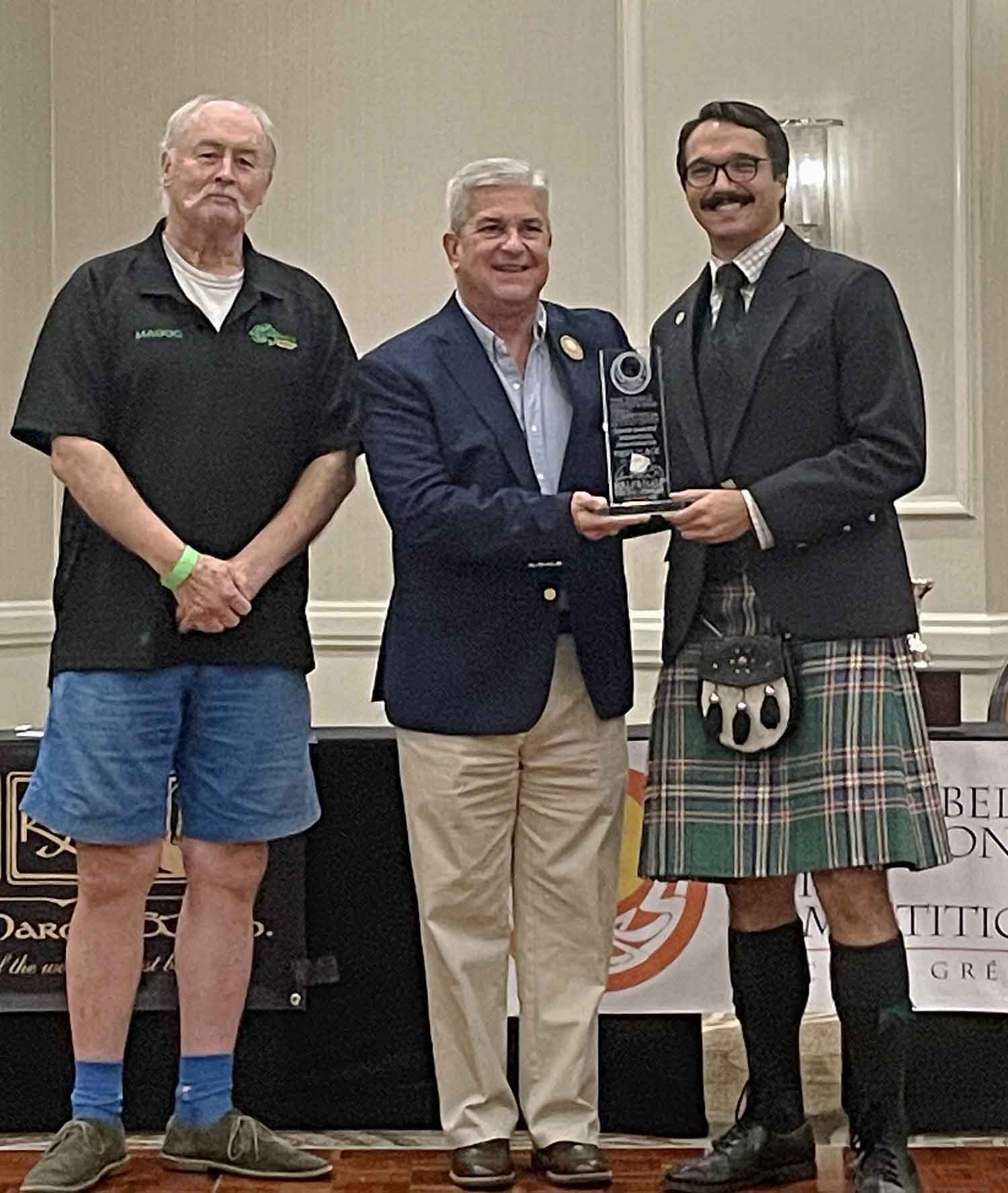 Tom Cangelosi (right) receives the 2023 Sandy Jones Memorial Amateur Invitational Trophy from EUSPBA President Bill Caudill (centre) and Vice-President Joe McGonigal.