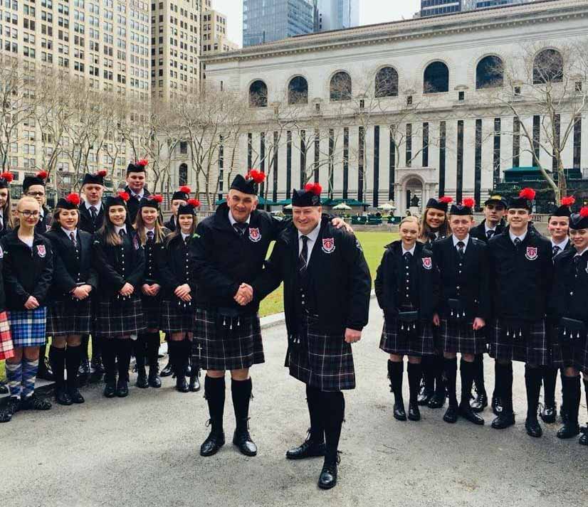 Domhnall Ban MacDonald and another teacher with Sgoil Lionacleit pupils at Bryant Park in Manhattan during the 2018 Tartan Day festivities.