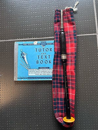 My first practice chanter, by R.G. Lawrie, a chanter bag made by my mom, and the "Scottish Pipe Band Association" Tutor and Text Book that we used.