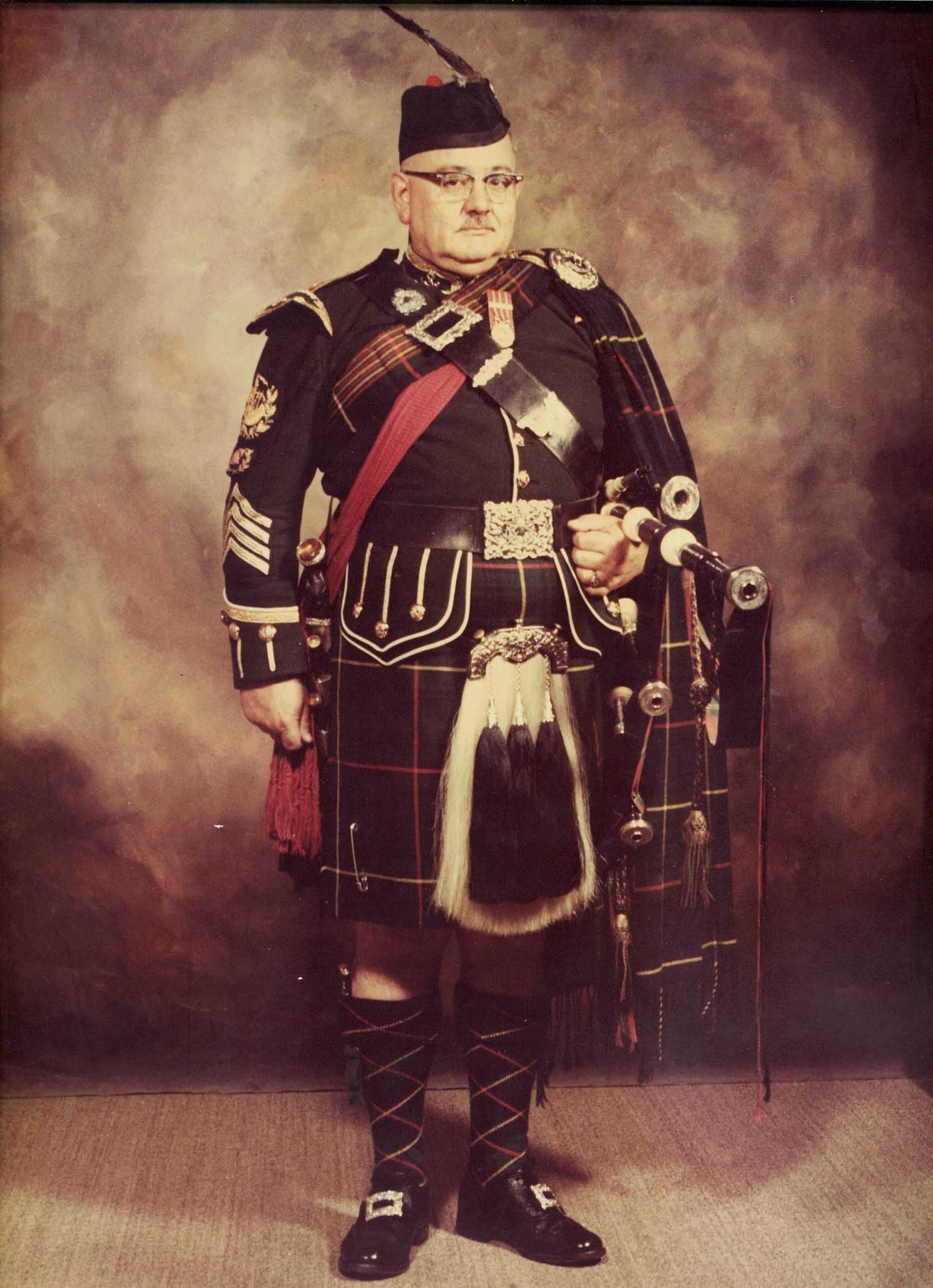 Piping patriarch Ray Gandy, holding the original pipes, c.1973.