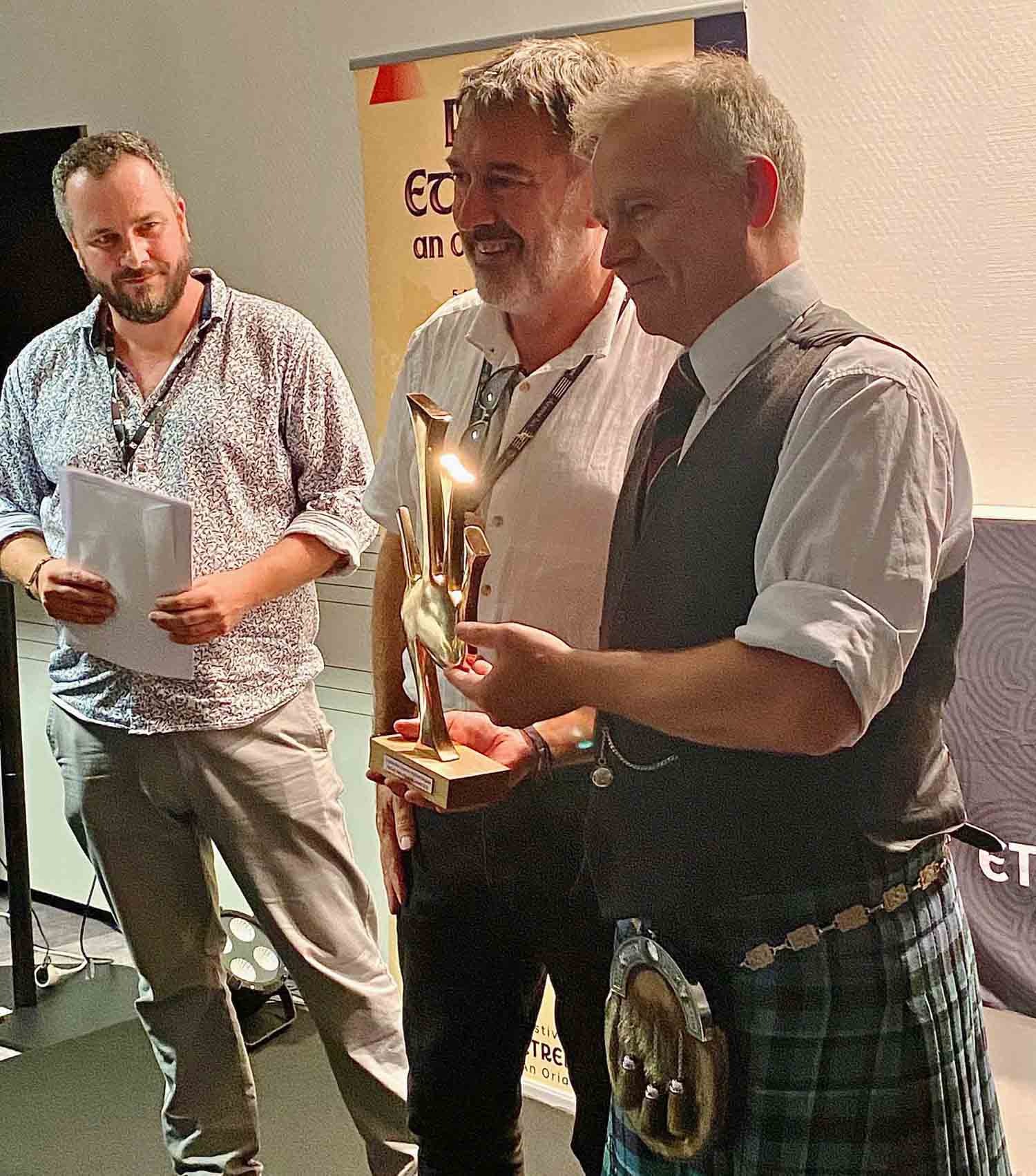 Stuart Liddell (right) receives the MacCrimmon Trophy from event organizers at the 54th annual Festival Interceltique de Lorient.