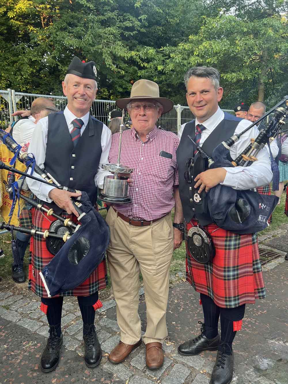 Richard Parkes, Ian McLellan and then future FMM Pipe-Major Matt Wilson share FMM's historic 2022 Worlds win.
