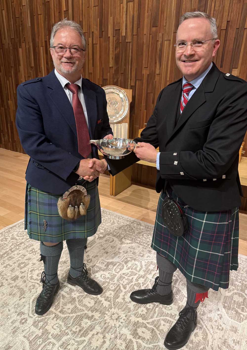 USPF organizer Mike Rogers (right) presents 2026 Champion Bruce Gandy with the St. Andrew’s Society of Philadelphia Silver Quaich for Professional Piobaireachd