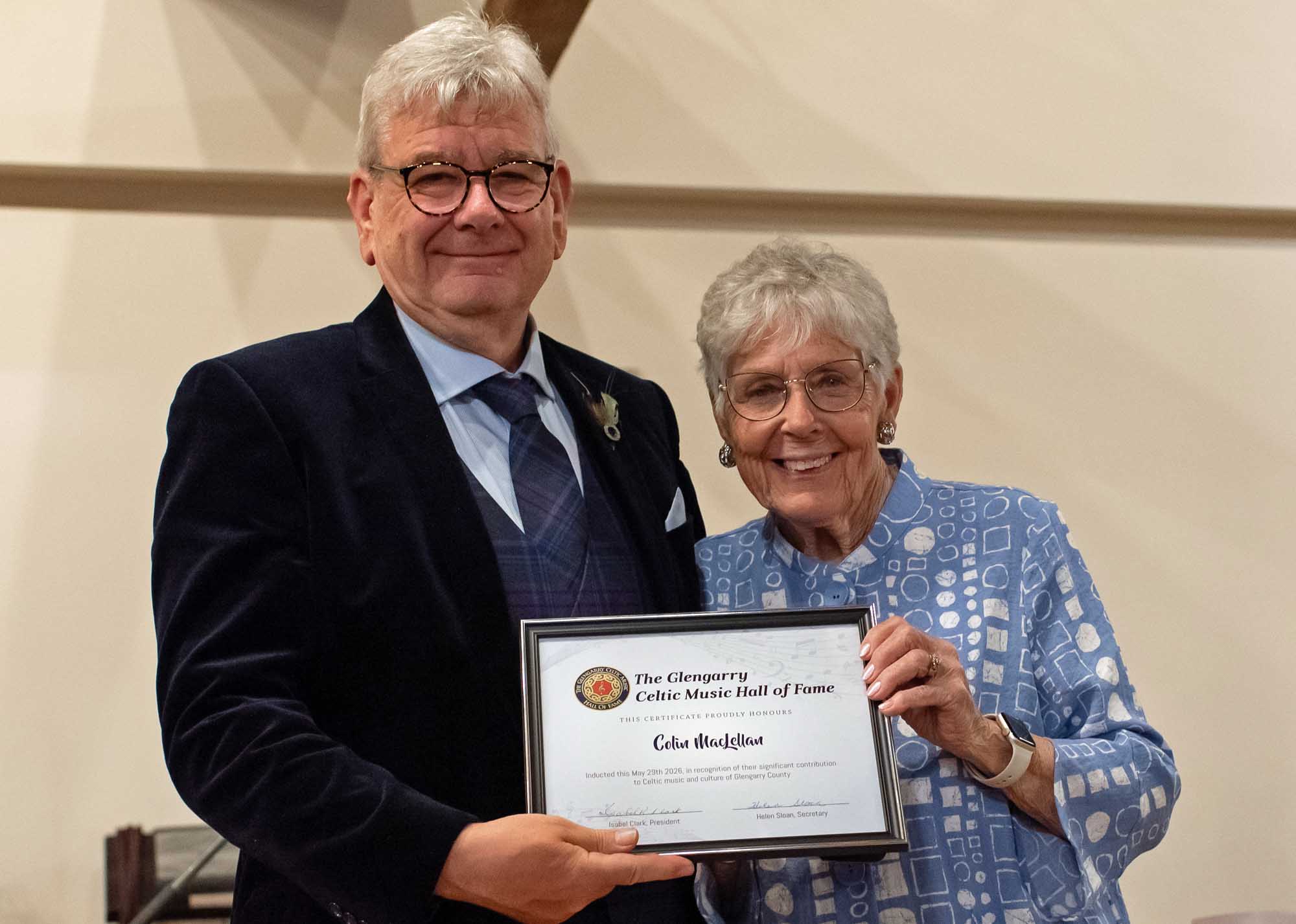 Colin MacLellan receives his certification as the latest inductee to the Glengarry Celtic Music Hall of Fame from Isabelle McCuaig, past president of the Glengarry Celtic Music Hall of Fame and the Glengarry Pipe Band Association.