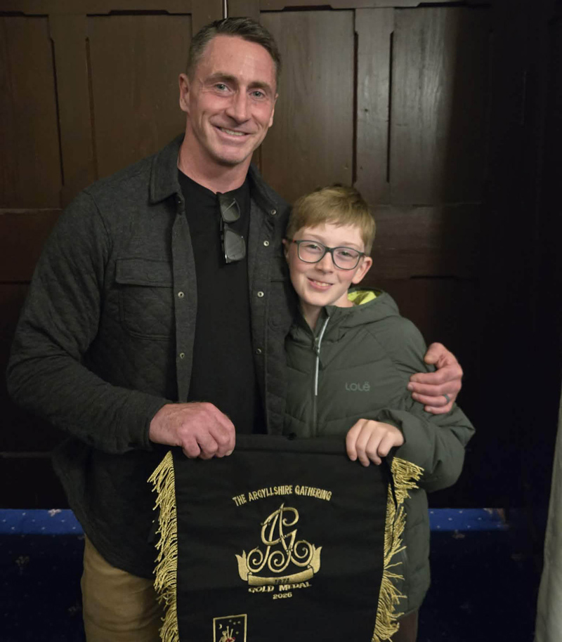 Sean McKeown with the presentation banner for winning the Oban Gold Medal, with his "good luck charm": his son, Charlie.