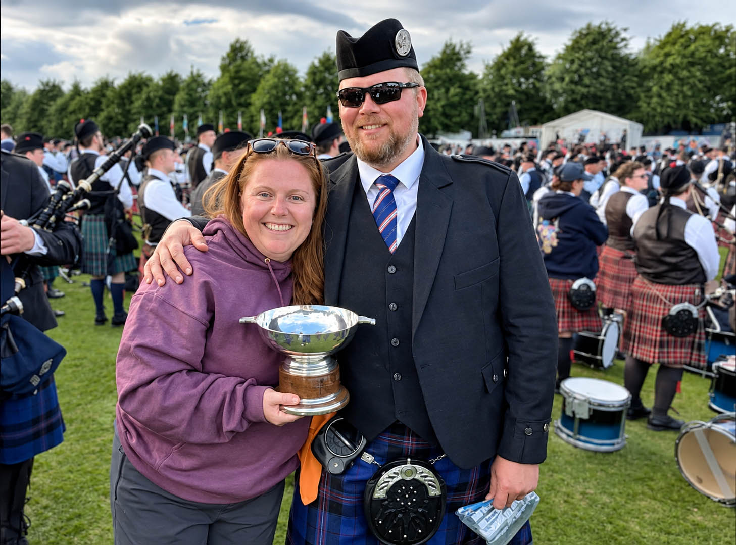 Ulster Scottish Pipe-Major Eric Ouellette with his wife, Addie Webb, with the 2026 Grade 2 trophy at the 2026 Worlds.