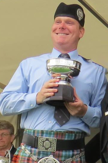 Mike Mahoney with the trophy for fourth in Grade 2 at the 2013 World Pipe Band Championships.