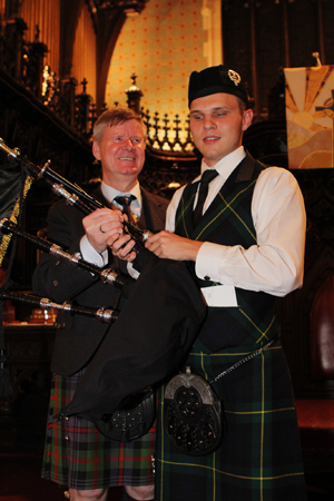 2015 Sherriff Memorial champion Austin Diepenhorst (right) receiving a set of McCallum pipes from judge Ian Duncan.