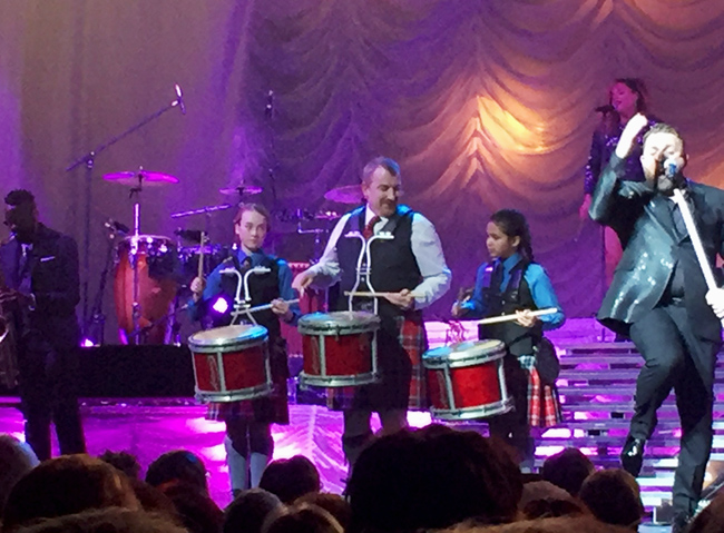 Johnny Reid (right) performing "My Heart Beats Like a Drum" with drummers from the Conservatory of Performing Arts Pipe Band (University of Regina) at the Conexus COA in Regina, February 16th.