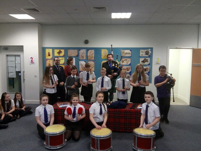Fintry Primary School, students ready to take on the world. L-R: Gregor Murray, Children and Families Convenor, Dundee City Council; Alexandra Duncan, Chief Executive, Scottish Schools Pipes and Drums Trust; Pipe-Major Derek Potter, and kids already in the program.