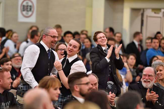 Tenor drummer Katie Byzewski and her parents celebrate her success at Winter Storm as the winner in the Novice grade, while her piper, Meridith Richmond, applauds.