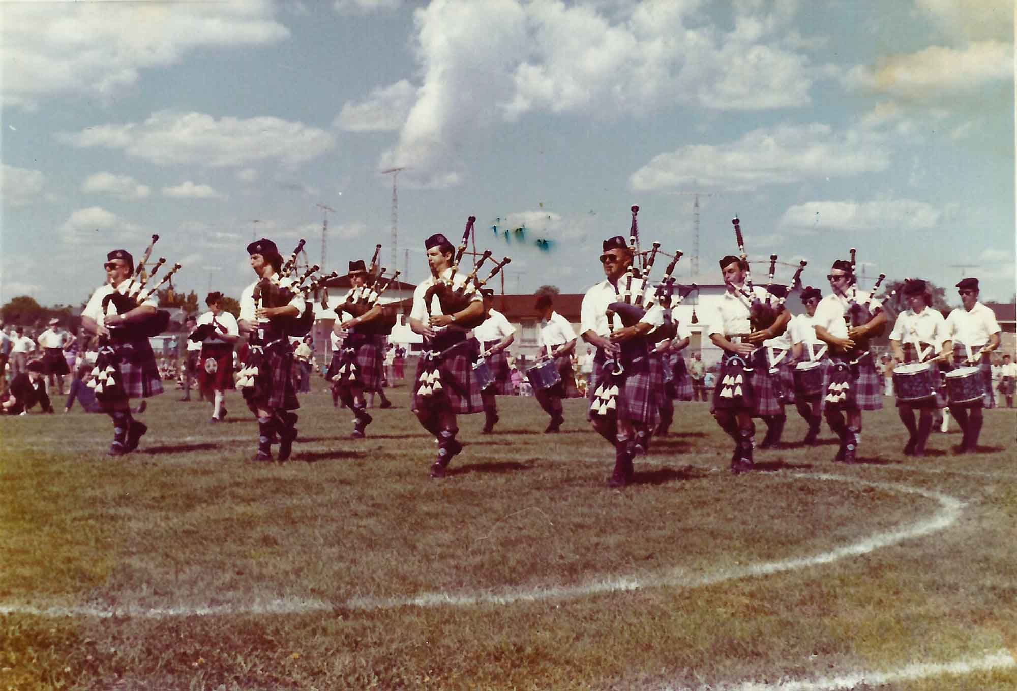 CFB Rockcliffe Pipe Band in Grade 1 event at Cobourg Highland Games in 1972: Front Row: P-M Archie Cairns, Michael MacDonald, Angus MacDowell, Charlie Bell; Adam Annandale (behind Charlie Bell), Stan (Sonny) McTavish behind Adam. Stuart McBride third row between Archie and Michael. First drummer on the right is Trevor Ferrier, and drummer Donald MacMillian is between Adam and Charlie.