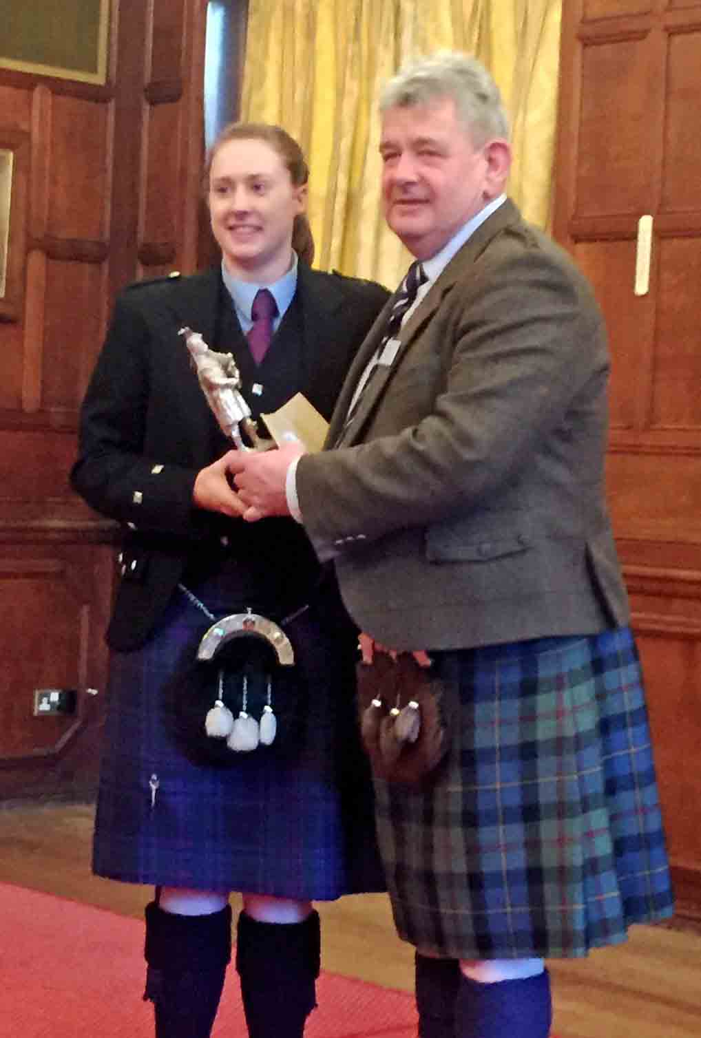 Sara Muir accepts the Army School of Bagpipe Music and Highland Drumming Memorial Trophy for the overall A-Grade.
