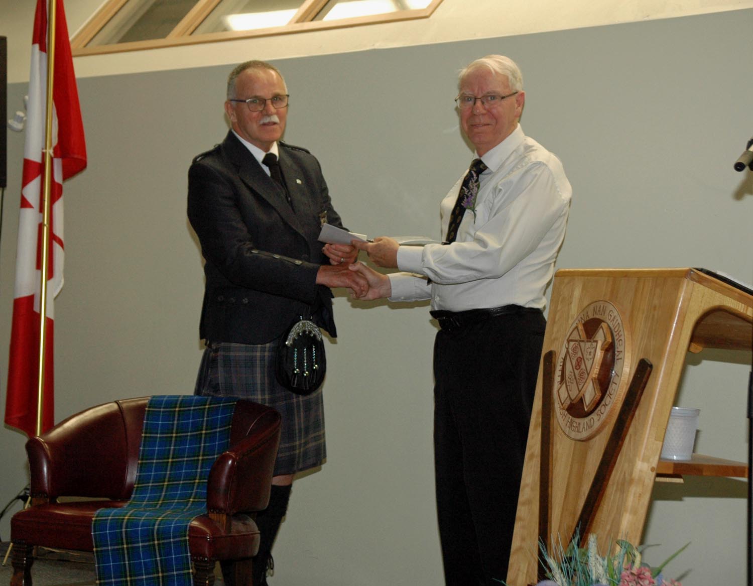 Barry Ewen receiving Hall of Fame induction certificate from Robert Cochrane, President of the Antigonish Highland Society