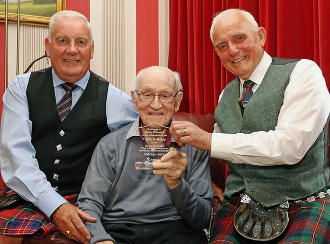 James Warnock (centre) presented with a special award from the RSPBA's Northern Ireland branch from RSPBA NI President Winston Pinkerton (left) and Vice-President Lowry Ferguson for Warnock's contributions to local and world piping.