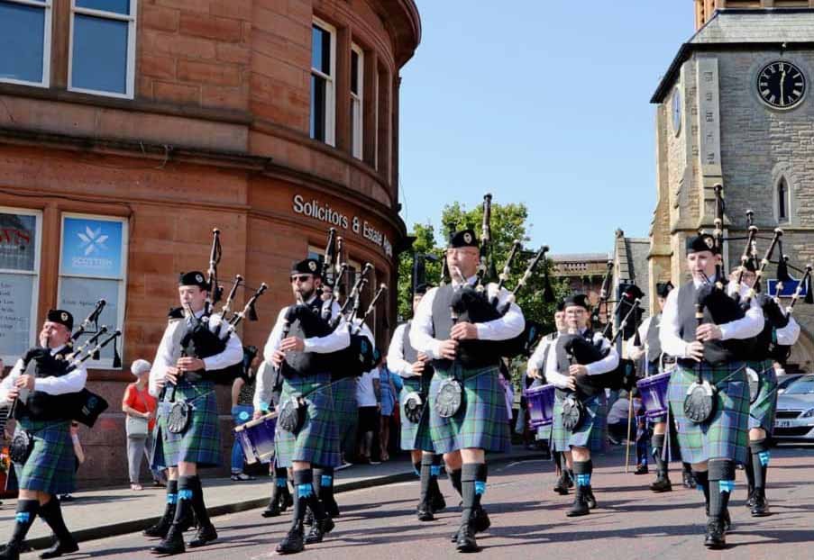 The Kilmarnock Pipe Band marching through the village's town centre, 2019.