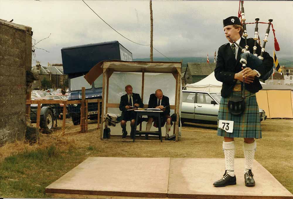 The author tuning at Crieff Games many years ago. The judges barely survived a full day of performances that, like every piping contest, were probably half tuning.