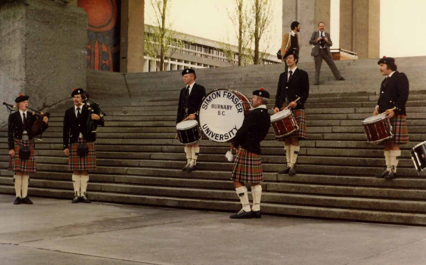 The first known photo of SFU Pipe Band, April 1, 1981, on 'Convocation Steps' at the university. Andrew Bonar is at far left, with Pipe-Major Terry Lee next to him, L-D Davie Bruce, bass drummer George McKillop, Steve Rickson and Terry Dalziel. The band was still wearing the old Port Moody Pipe Band kilts.