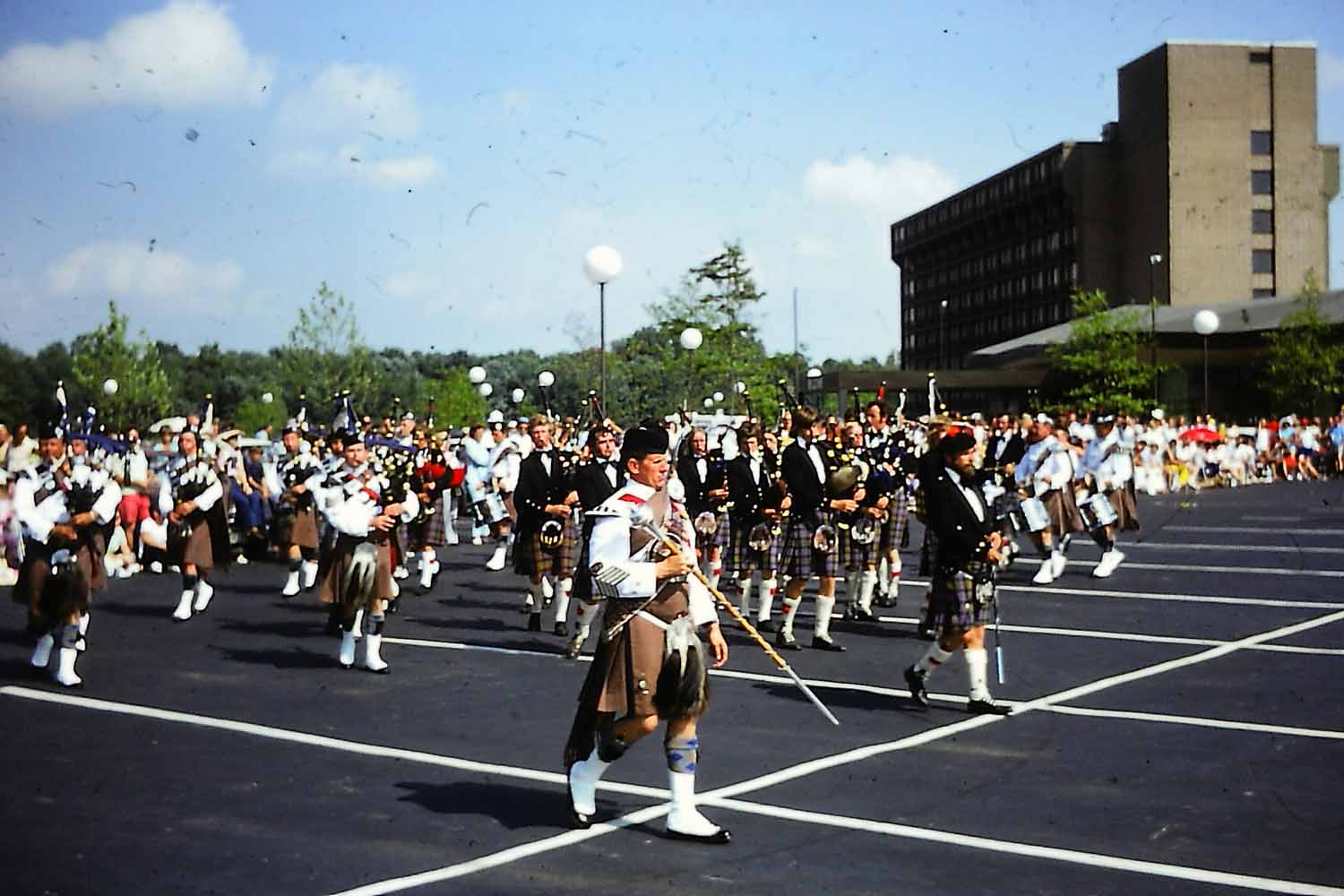 Pipe bands performing at the St. Louis Highland Games, July 1975, in Earth City, Missouri. That's the legendary Drum-Major Norman MacKenzie.