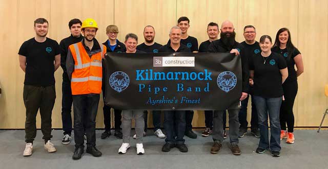 Members of Kilmarnock Pipe Band and 3b Construction celebrate their partnership.