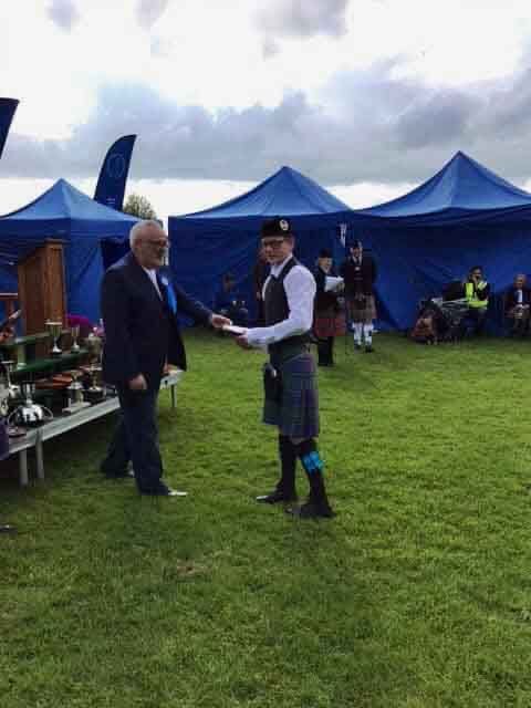 Warren Graham accepting a trophy on behalf of the Kilmarnock Pipe Band.